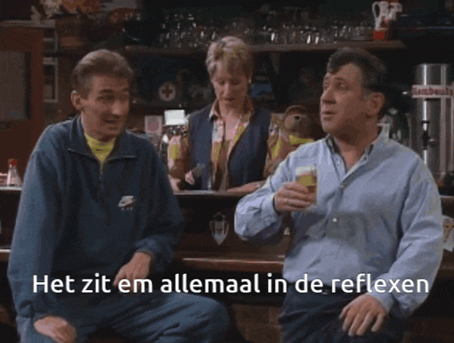 a man in a blue nike jacket holds a glass of beer