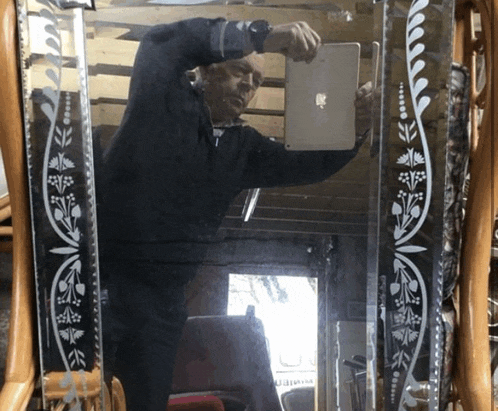 a man is taking a picture of himself in a mirror with a floral design