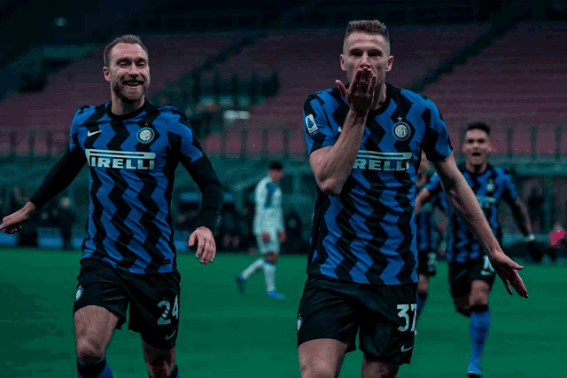 two soccer players wearing blue and black jerseys with the letters irelli on them