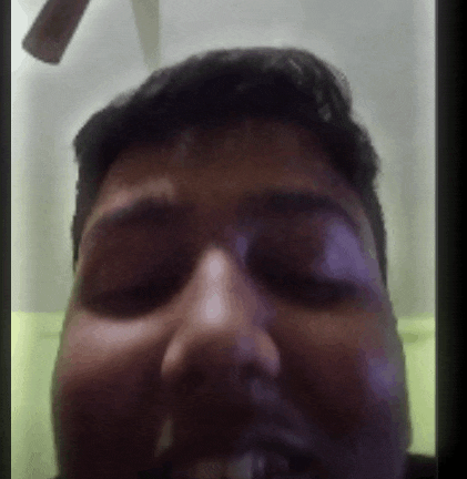 a close up of a man 's face with his eyes closed and a ceiling fan in the background .