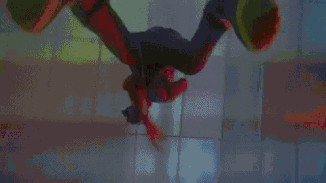 a person is flying through the air in a dark room with a red light behind them .