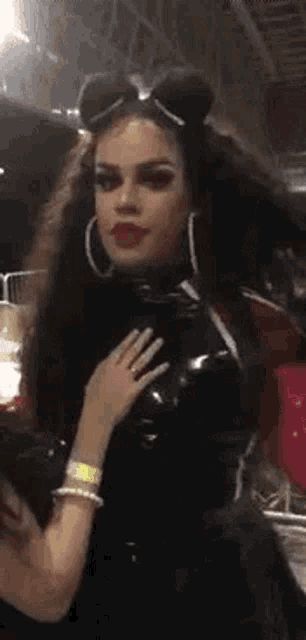 a woman in a black dress and hoop earrings is being held by a woman .
