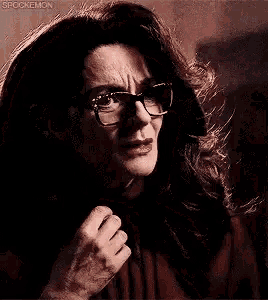 a close up of a woman wearing glasses and making a funny face .