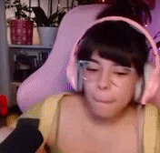 a woman wearing pink headphones and glasses is sitting in a pink chair .