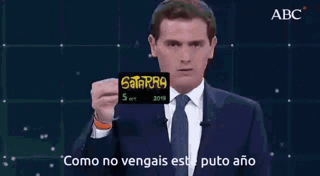 a man in a suit and tie is holding a card that says satarra on it