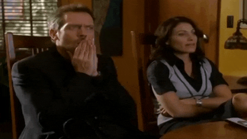 a man and a woman are sitting at a table and the woman is smiling
