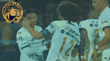 a soccer player wearing a number 12 jersey is hugging another player
