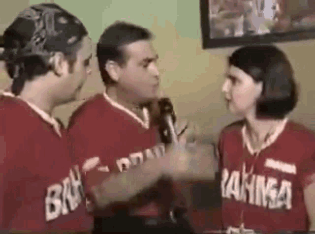 a man and a woman are talking to each other and the man is wearing a shirt that says ' bah ' on it