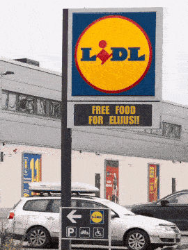 a sign that says free food for elijus sits outside of a store