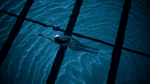 a person is swimming in a pool with the word swimsuit on their back