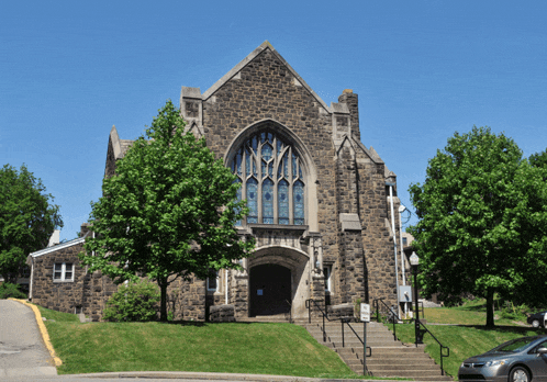 a brick building with a stained glass window and stairs
