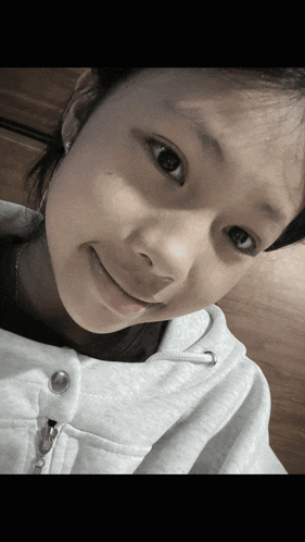a close up of a girl 's face with a white shirt on