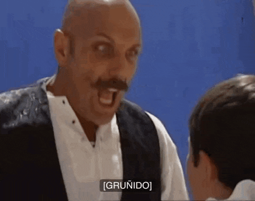 a bald man with a mustache is yelling at a child .