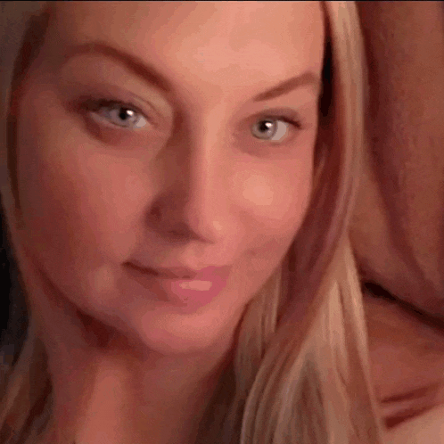 a close up of a woman 's face with blue eyes and blonde hair