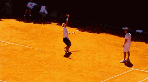 two men are playing tennis on a court and one of them is wearing a white shirt that says ' ralph lauren ' on it