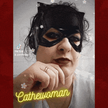a woman wearing a catwoman mask with the word catwoman written above her