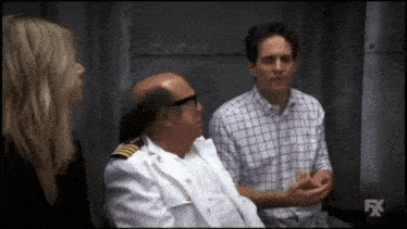 a man in a military uniform talks to two other men