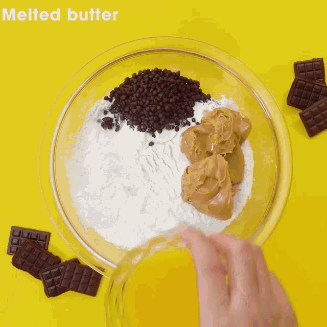 a glass bowl filled with eggs , chocolate chips , peanut butter and yogurt
