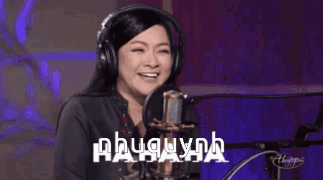a woman wearing headphones is singing into a microphone with the name phuquynh on the bottom right