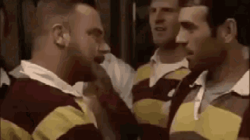 a group of men in striped shirts are standing next to each other .