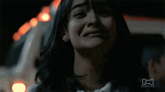 a close up of a woman 's face with a tear coming out of her eye