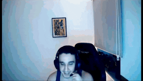 a man wearing headphones is sitting in front of a framed poster that says fly like a spider live like a bee