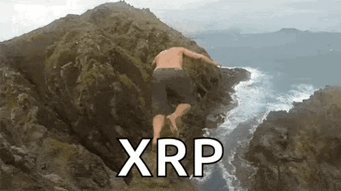 a man is jumping off a cliff into the ocean while wearing shorts .