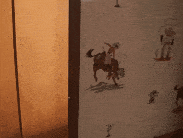 a cowboy riding a horse on a wall with other cowboys