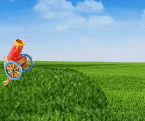 a colorful cannon is sitting in the middle of a green field