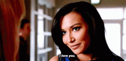 a woman is standing in a hallway talking to someone and saying `` i love you '' .