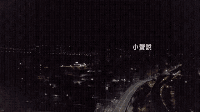 an aerial view of a city at night with chinese writing on the bottom
