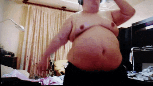 a man without a shirt is standing in a room