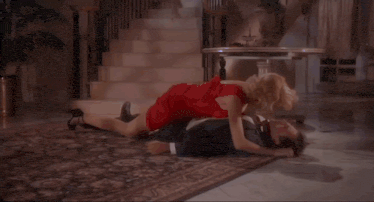 a woman in a red dress is laying on the floor with a man in a red shirt .