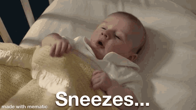 a baby is laying in a bed and sneezes