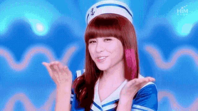 a woman in a sailor outfit is making a funny face while wearing a hat .
