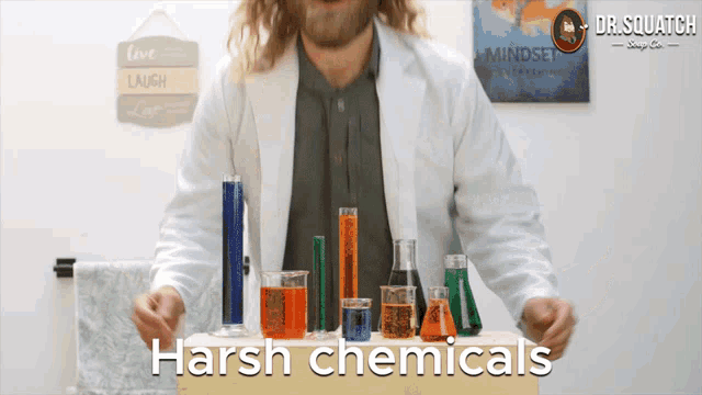 a man in a lab coat stands in front of a table full of chemicals with the words harsh chemicals below him