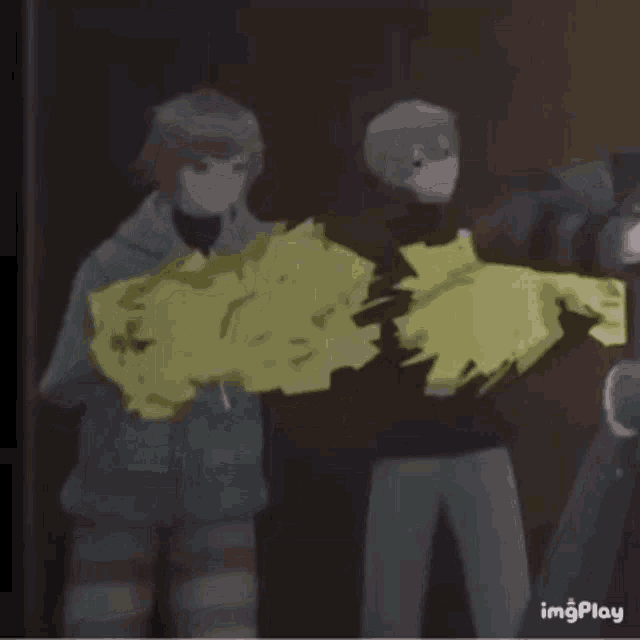 a group of people are standing next to each other in a dark room holding a yellow object .
