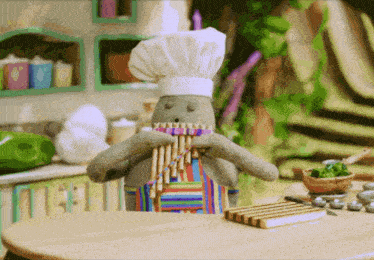 a stuffed animal is wearing a chef 's hat and apron and playing a flute