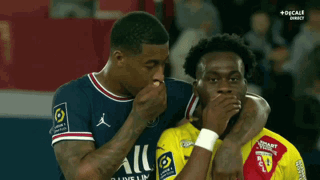 two soccer players covering their mouths with their hands while wearing jordan jerseys