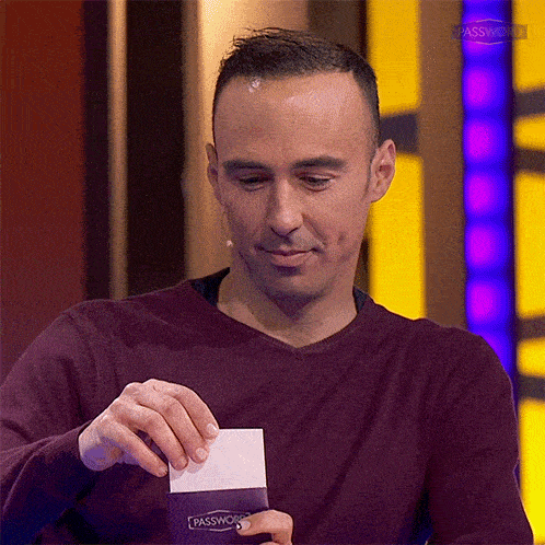 a man in a maroon sweater is holding a piece of paper that says passwo