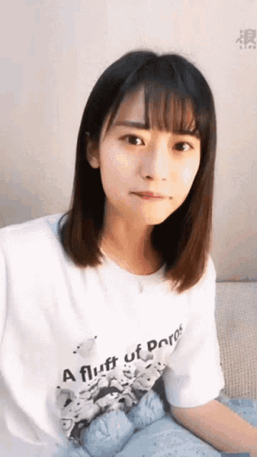 a young woman wearing a white shirt that says a fluff of poros