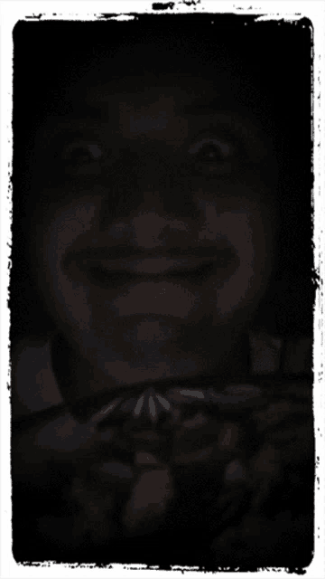 a man 's face is visible in a dark photo frame