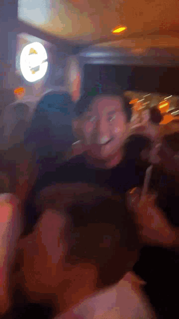 a group of people are dancing in a room with a sign that says e on it
