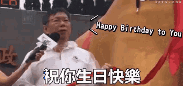 a man is holding a microphone and says happy birthday to you