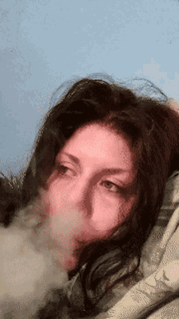 a woman is blowing smoke out of her mouth