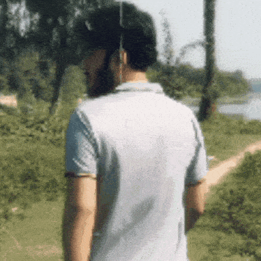 a man with a beard is standing in a field looking at the camera .