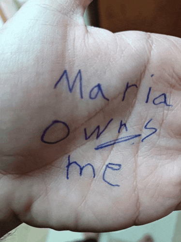 a person 's hand has the words maria owns me written on it