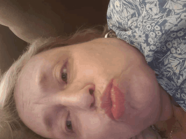 a close up of a woman 's face with a blue and white shirt on