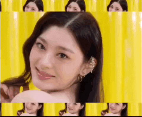 a woman is standing in front of a yellow curtain and smiling .