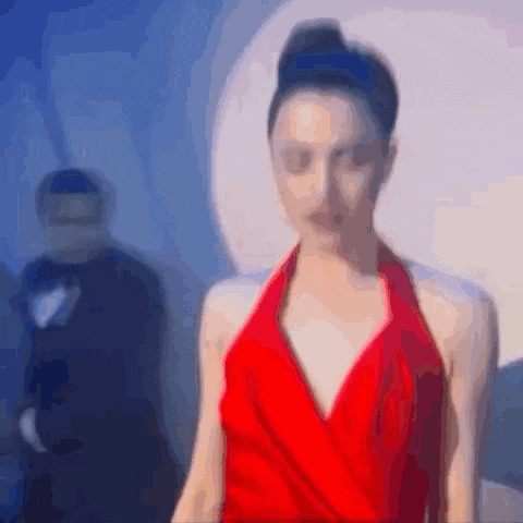 a woman in a red dress is standing in front of a man in a tuxedo ..
